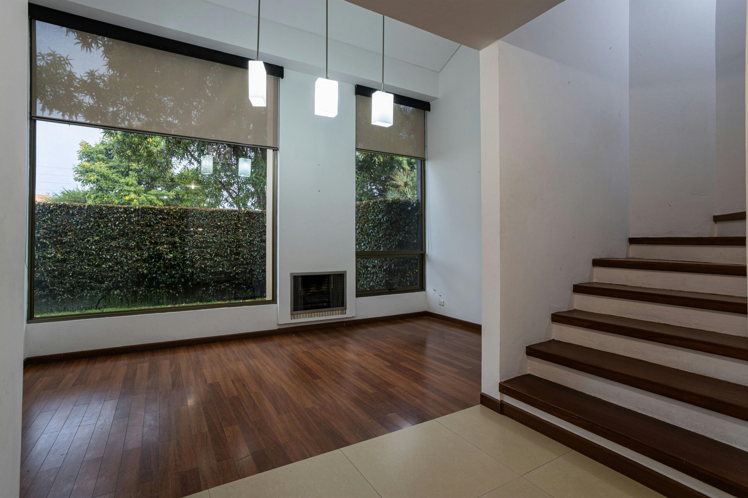 Bright and spacious interior featuring wooden floors and stairs, perfect for contemporary design themes.